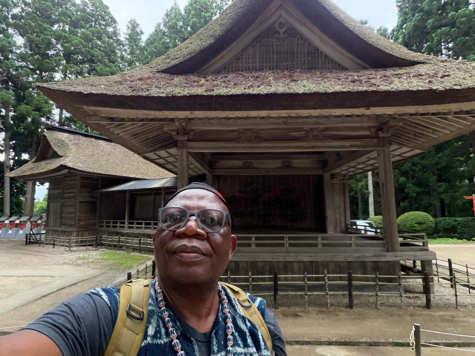 Pa Fru before a thatched shrine
