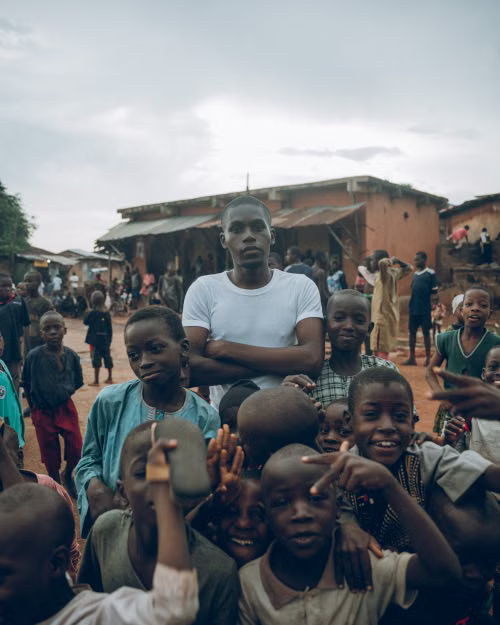 A young man standing with a group of village children