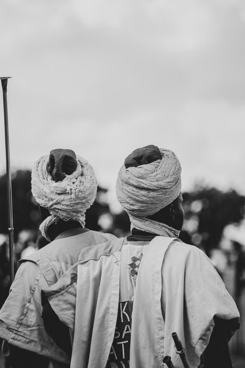 Two elders seen from behind wearing traditional turbans