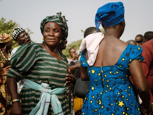 Women greeting one another in traditional dress